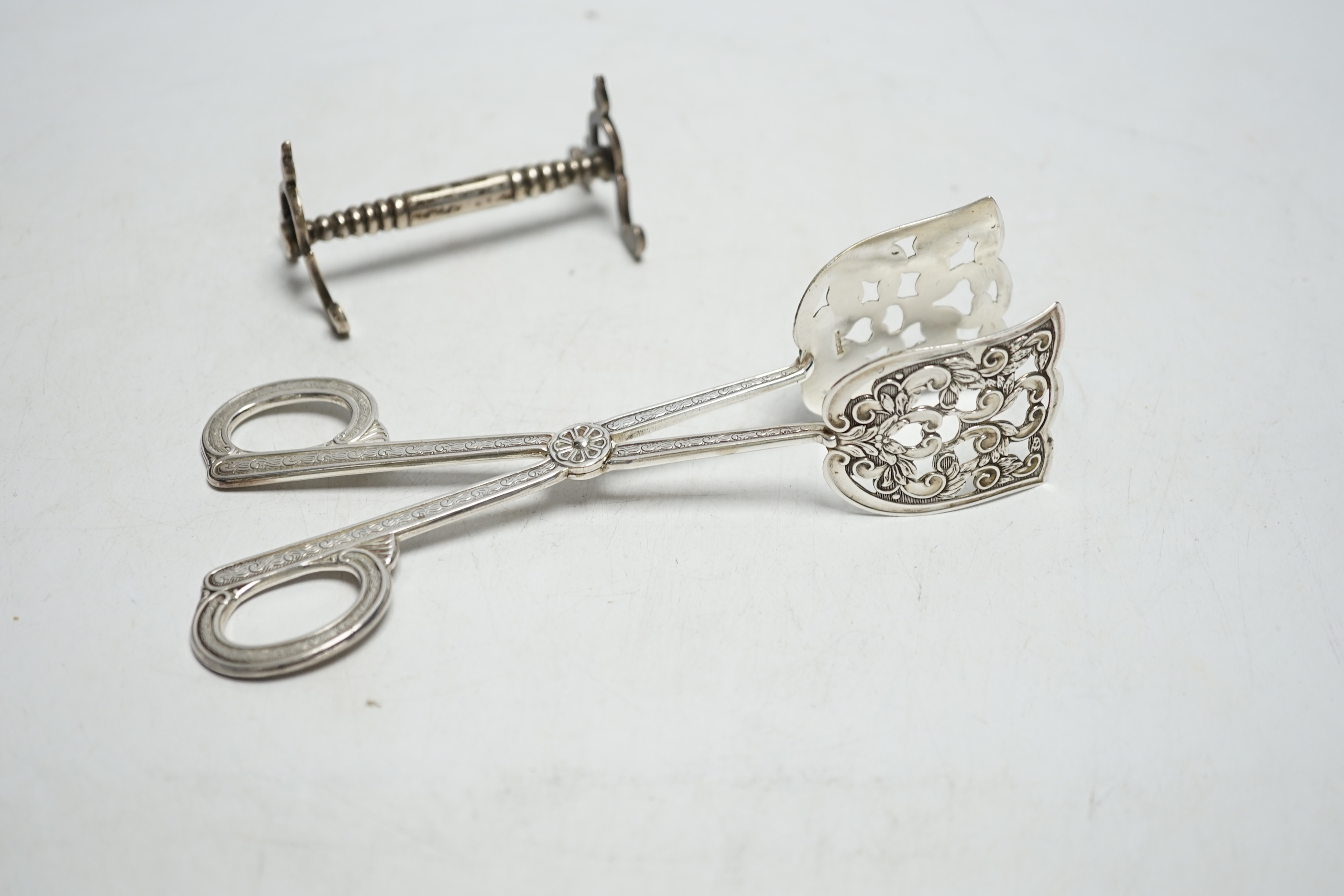 A pair of Swedish metal asparagus tongs and a pair of Edwardian silver knife rests, London, 1909.16.6cm